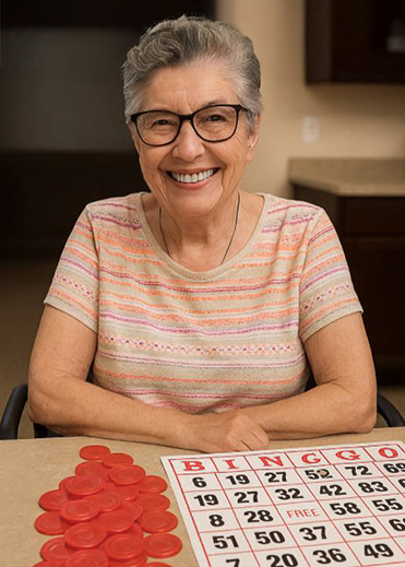 Smiling senior woman sits at a table with a bingo card and bingo chips.
